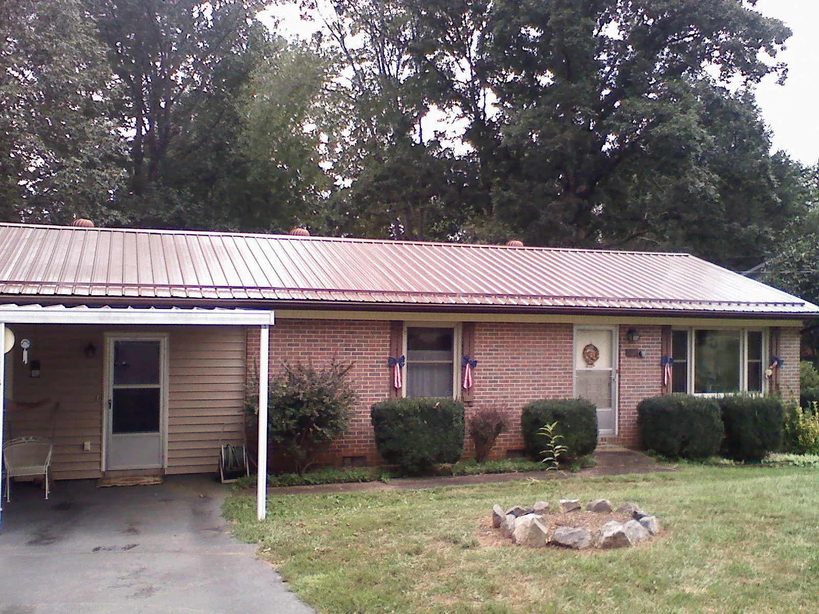 Bronze metal roof and carport on a brick ranch home — Roof Repair work by our crew in Garrison
